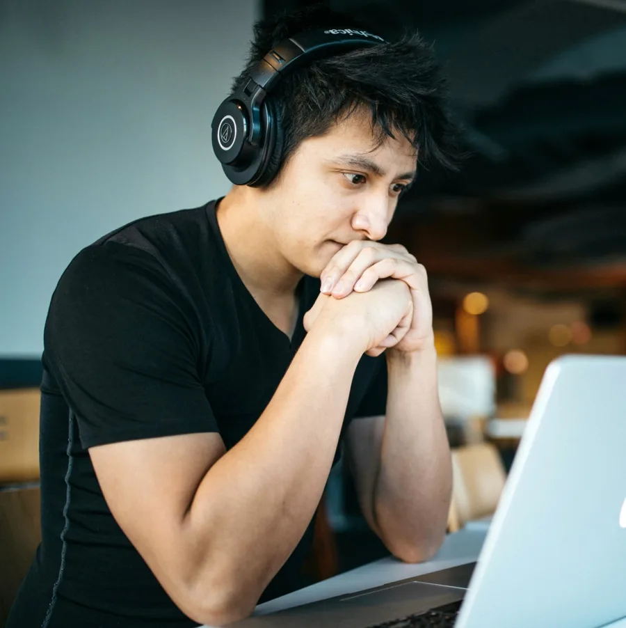 Student focused on a laptop, wearing headphones
