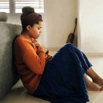 Person sitting with a hand on their stomach