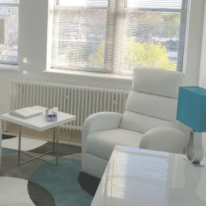 Bright consulting room, white armchair by a large window