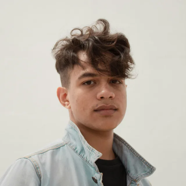 Adolescent en veste de jean, le regard posé vers l'objectif